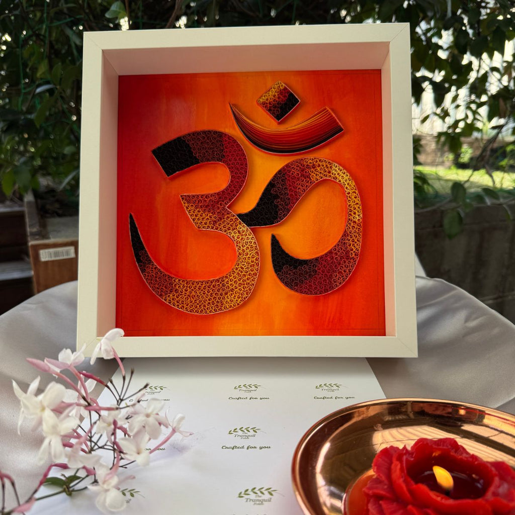Handcrafted Om paper quilling spiritual wall art with orange, gold, burgundy and black details on an Australian sunrise-inspired painted background.
