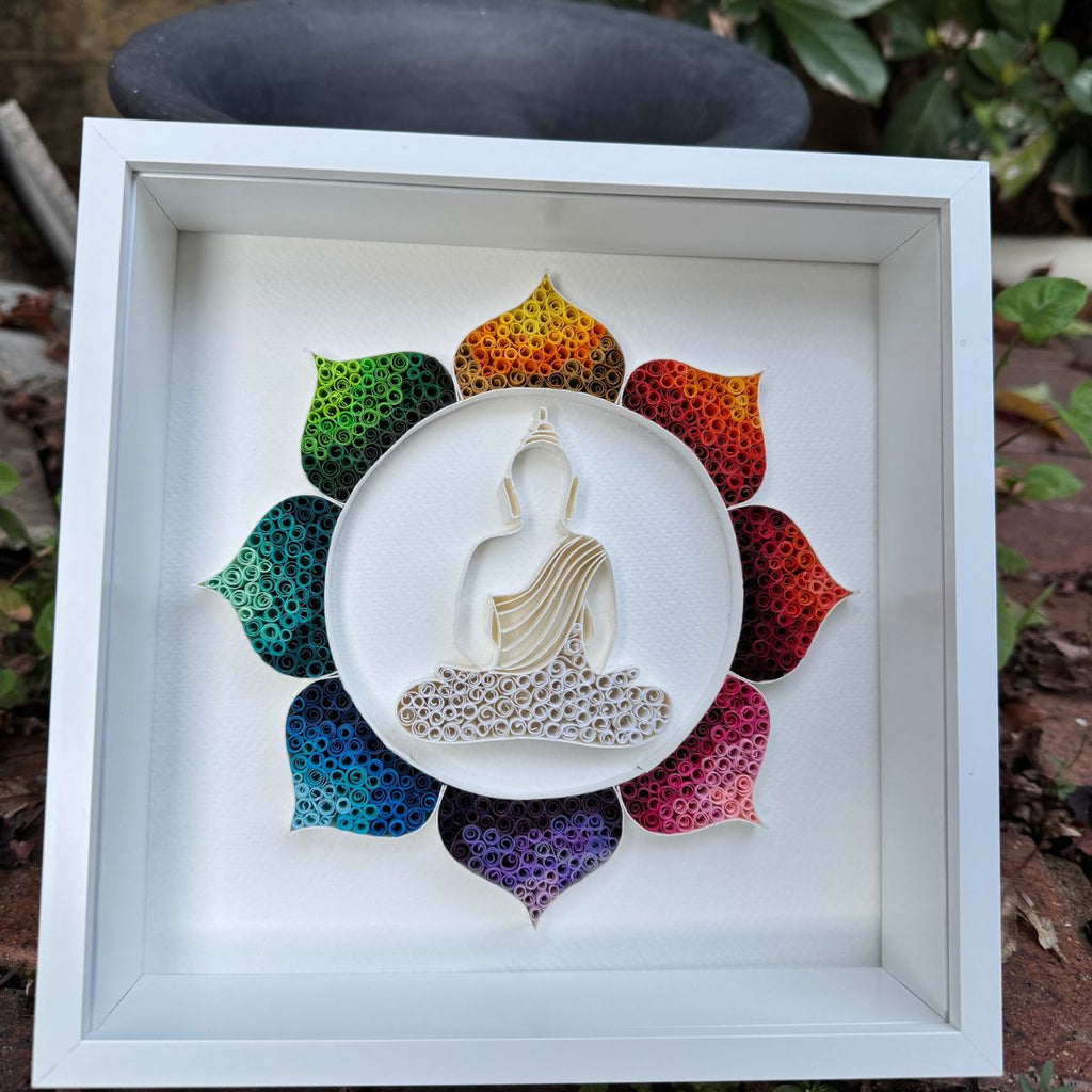 Handcrafted Radiant Lotus Buddha paper quilling wall art featuring a white Buddha silhouette surrounded by a vibrant rainbow lotus in a white shadow box frame.