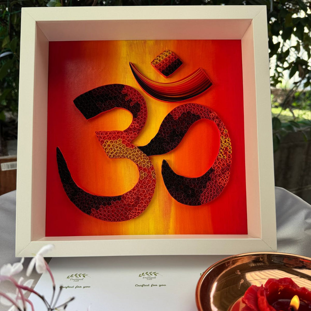 Handcrafted paper quilling OM artwork in red, orange, gold and black sunset tones, framed in white MDF
