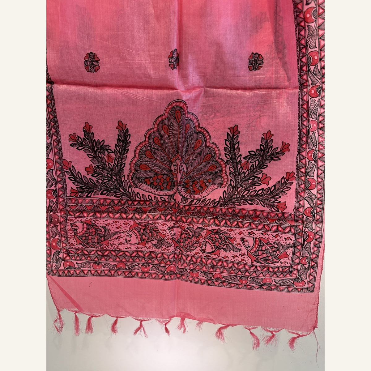 Close-up of original coral pink hand-painted Madhubani stole showing peacock, fish and detailed borders