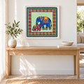 A Gentle Bond elephant Madhubani artwork in a white frame above an oak console