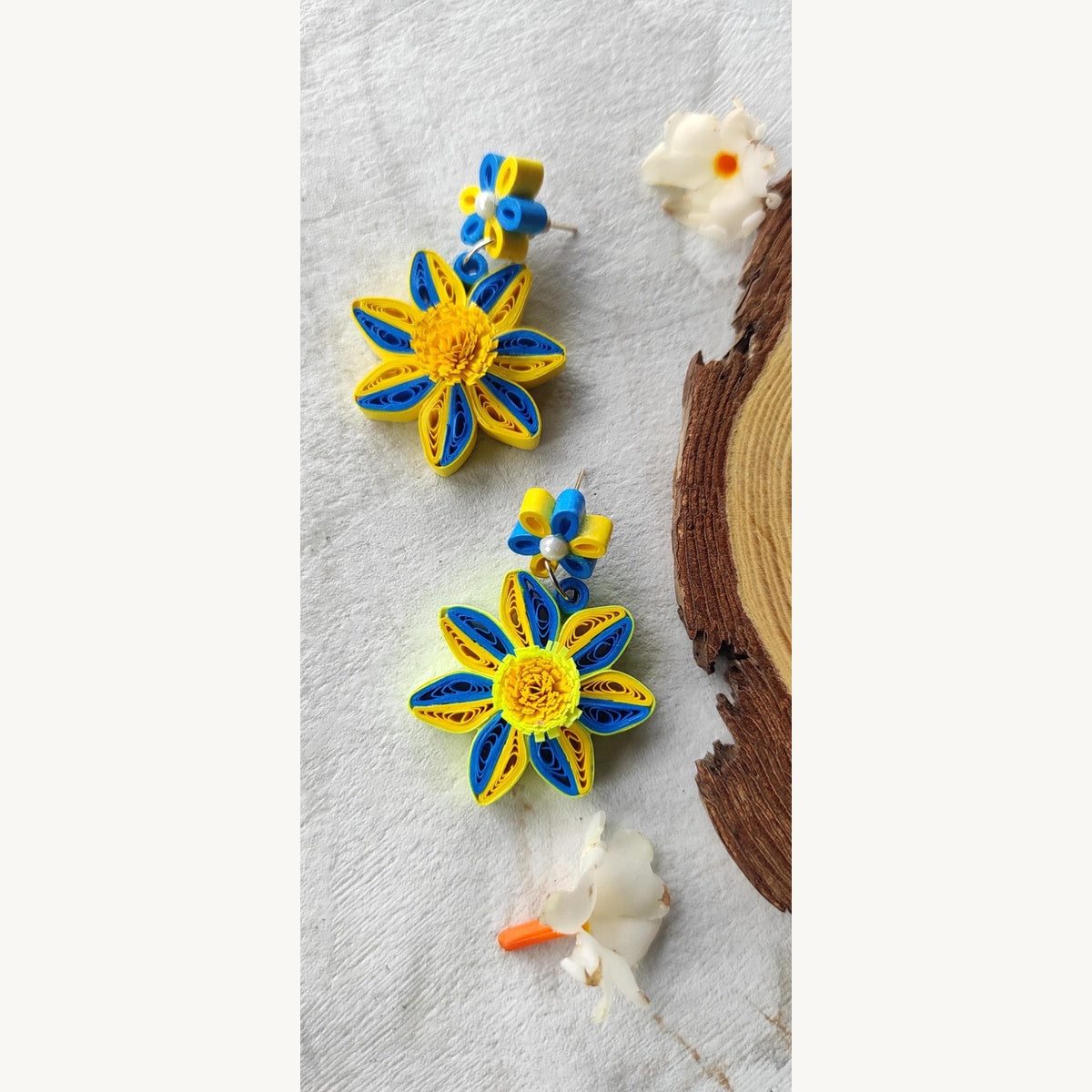Handcrafted yellow and blue paper quilling flower stud drop earrings with two-tone petals and pearl-look accents.