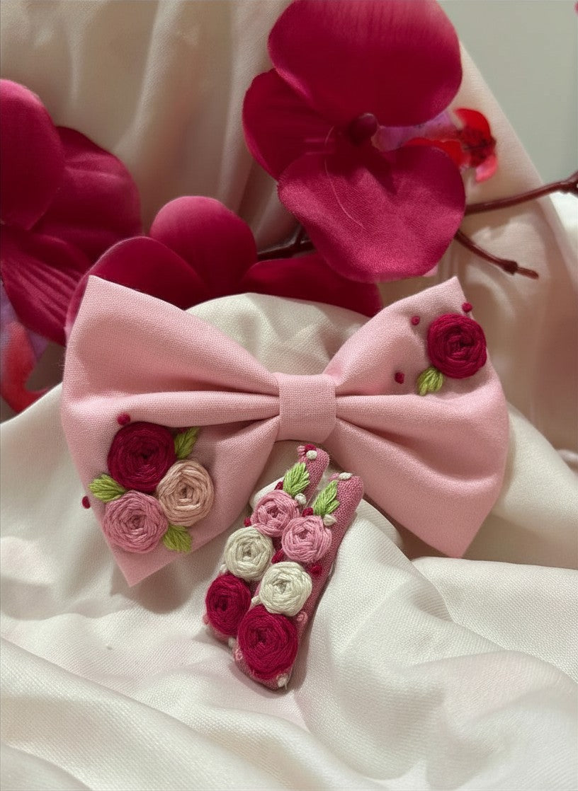 Handmade embroidered floral hair bow in pink and matching hair clip set featuring artisan rose embroidery and botanical detailing, beautifully crafted for gifting and special occasions.