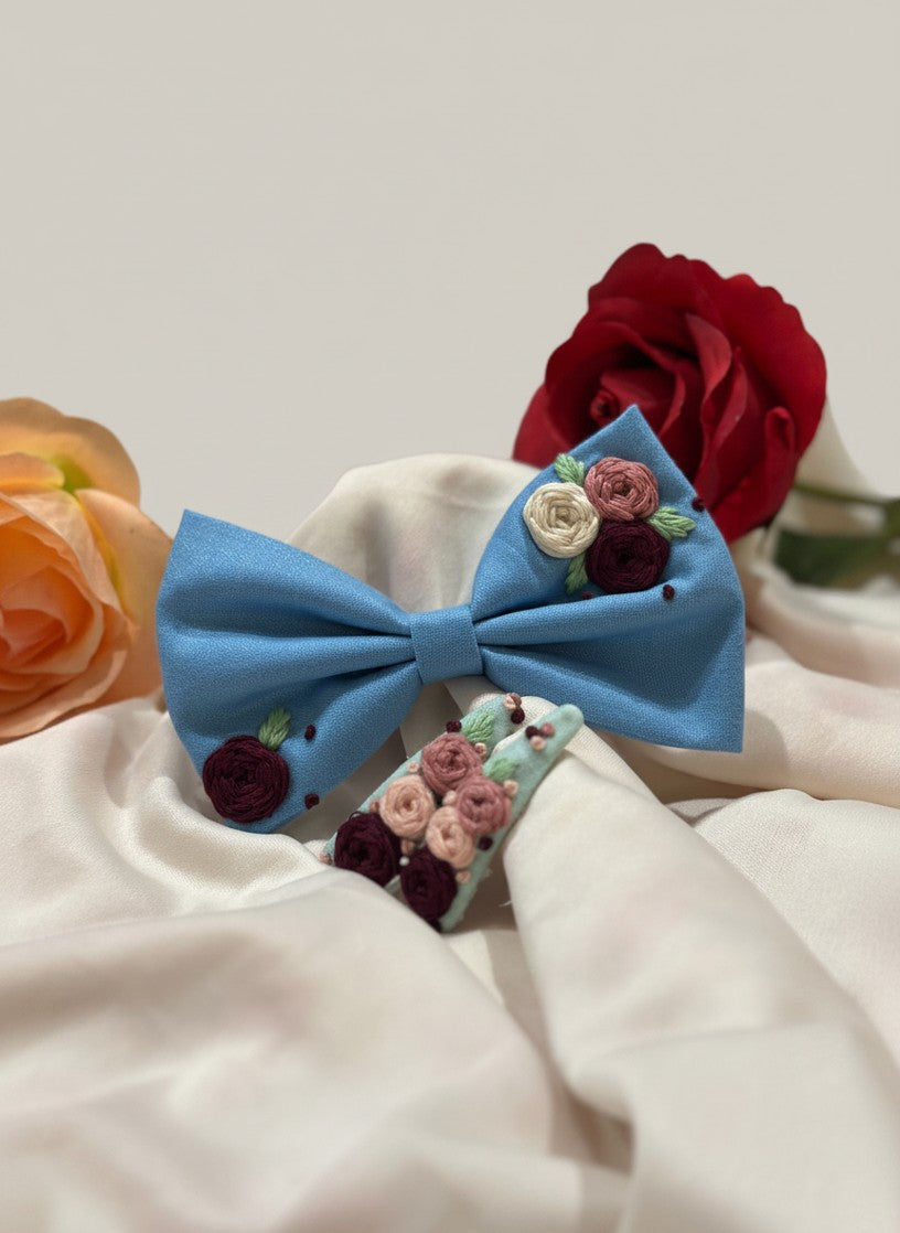 Handmade embroidered floral hair bow in sky blue and matching hair clip set featuring artisan rose embroidery and botanical detailing, beautifully crafted for gifting and special occasions.