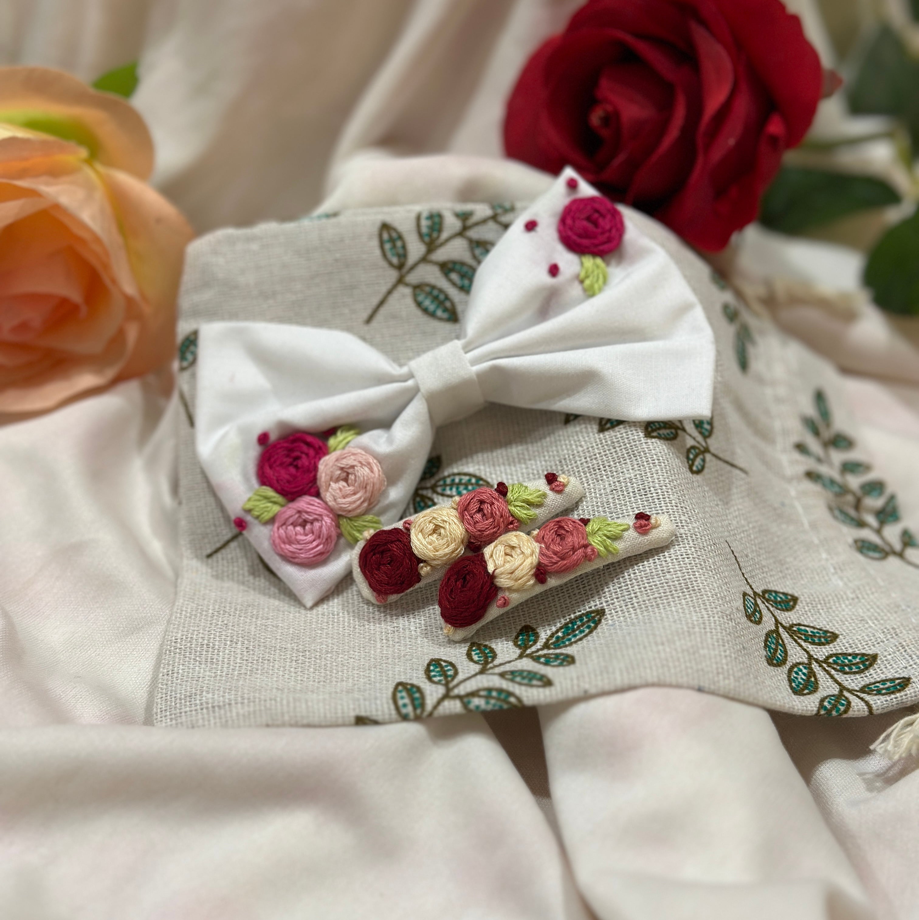 Handmade embroidered floral hair bow in white and matching hair clip set featuring artisan rose embroidery and botanical detailing, beautifully crafted for gifting and special occasions.