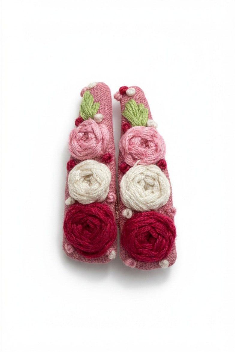 Hand embroidered floral tic-tac hair clip set on blush pink cotton with pink cream and crimson rose stitching