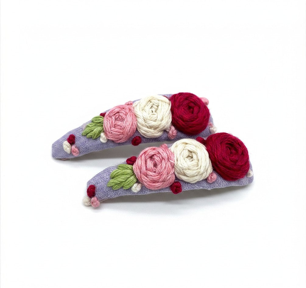 Hand embroidered floral tic-tac hair clip set on lavendar cotton with pink cream and crimson rose stitching