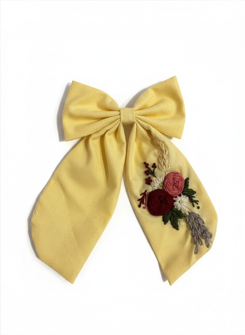 Large dusty yellow sailor bow with long flowing tails and alligator clip fastening — handmade artisan hair accessory