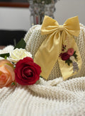 Large dusty yellow sailor bow with long flowing tails and alligator clip fastening — handmade artisan hair accessory