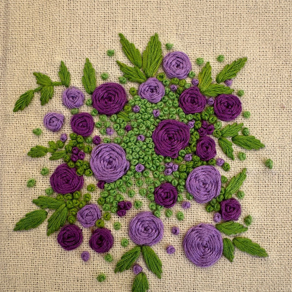 Hand embroidered floral journal with lilac and plum rose bouquet stitched on a pale lemon-yellow casement fabric cover.