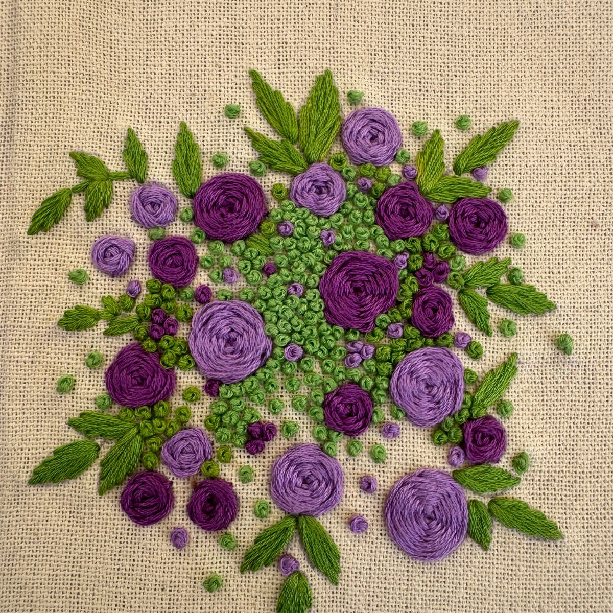 Hand embroidered floral journal with lilac and plum rose bouquet stitched on a pale lemon-yellow casement fabric cover.