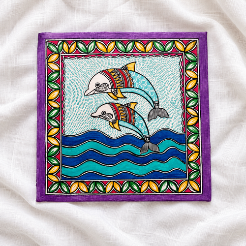 Turquoise dolphin Madhubani artwork laid on white linen