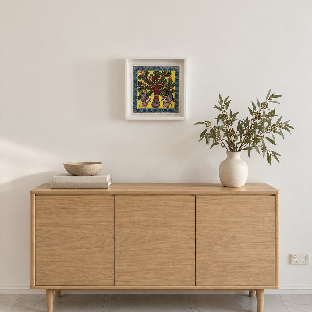Framed peacock and tree painting displayed above a light oak sideboard in a contemporary living room