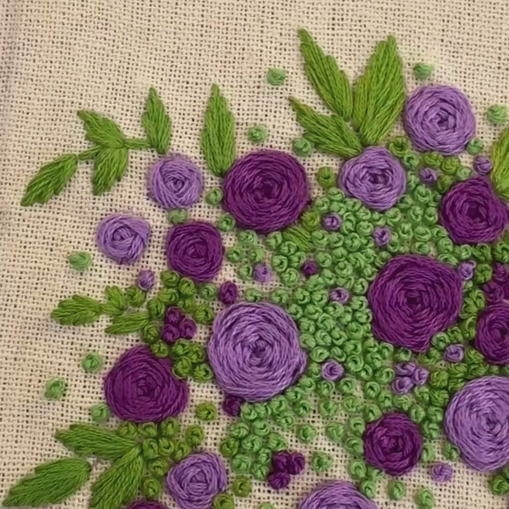 Hand embroidered floral journal with lilac and violet rose bouquet stitched on a pale lemon-yellow linen cover.