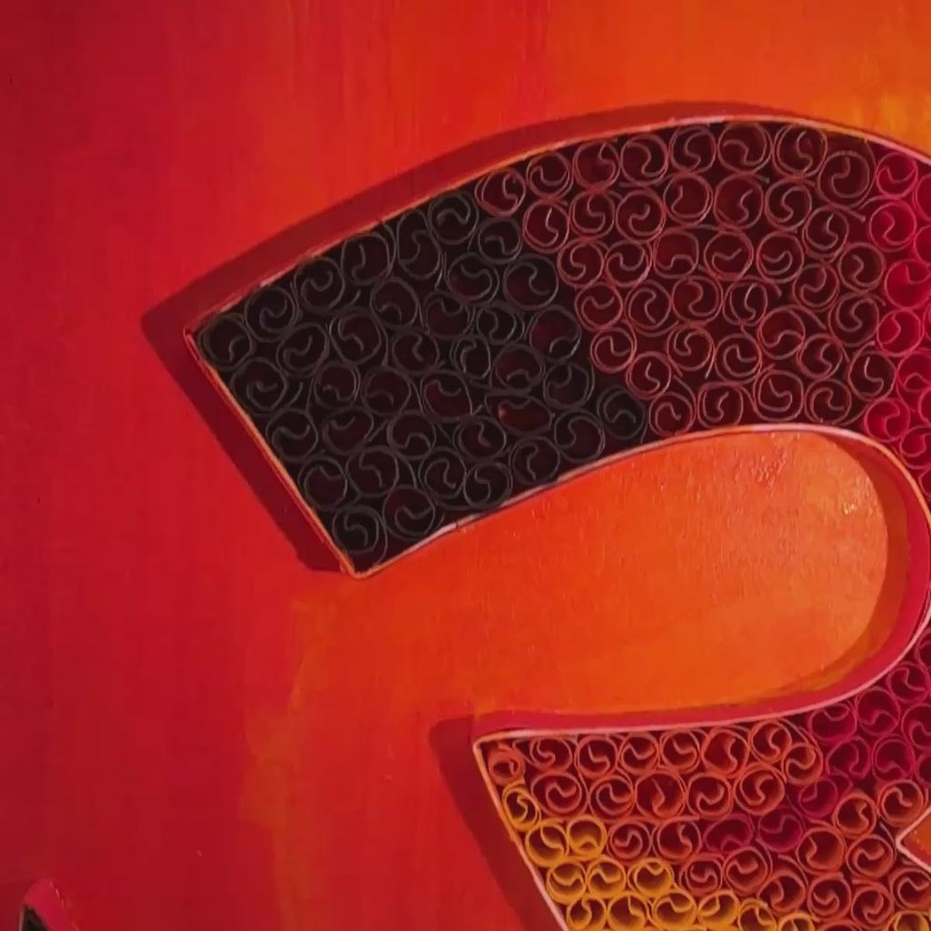 Handcrafted Om paper quilling spiritual wall art with orange, gold, burgundy and black details on an Australian sunrise-inspired painted background.