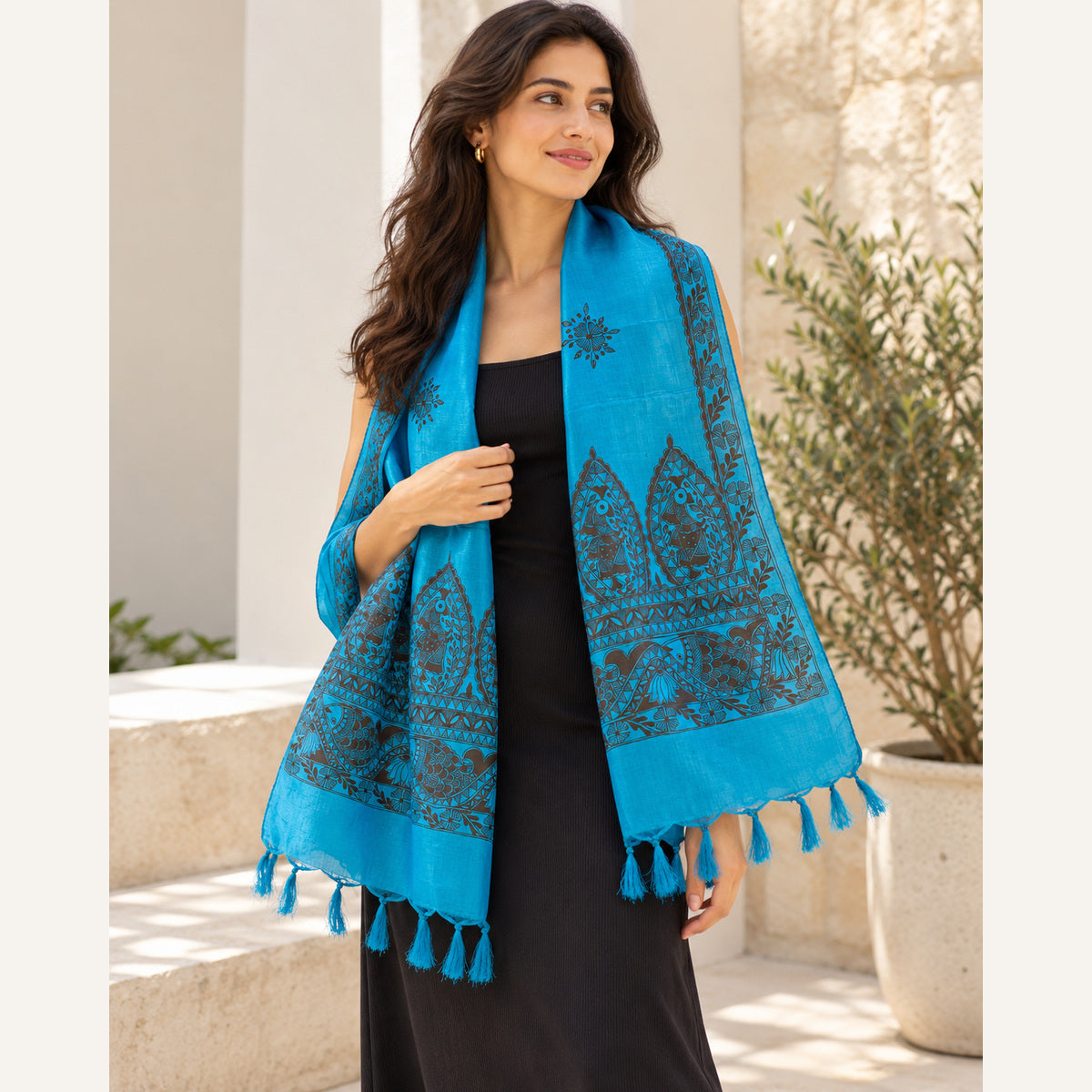 Hand-painted turquoise Madhubani art silk stole worn over a black western dress